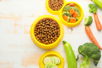 Composition with dry pet food and natural products on wooden background