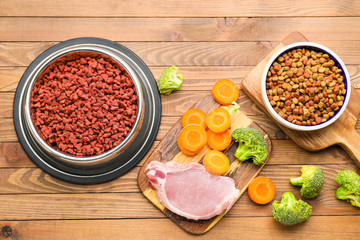 Composition with dry pet food and natural products on wooden background