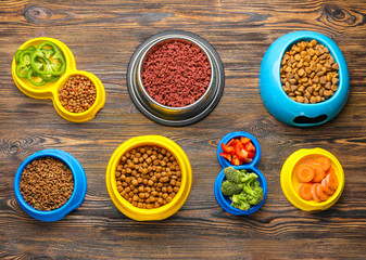 Composition with dry pet food and natural products on wooden background