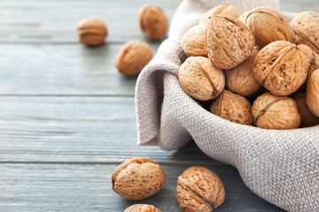Bowl with tasty walnuts on table