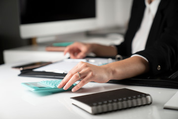 Office work. Cropped image of female employee working in office, supplies on tabletop.