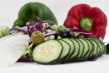 Close-up of sliced cucumber, chopped red cabbage, olives, spinach and chopped onions