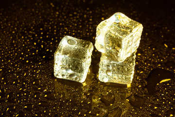 ice cubes on a reflections yellow light.