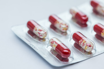 Capsules in a blister pack. Pills in foil blister packs, medications drugs on grey surface