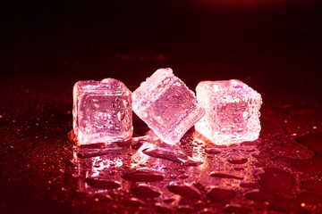 ice cubes on a reflections red light.