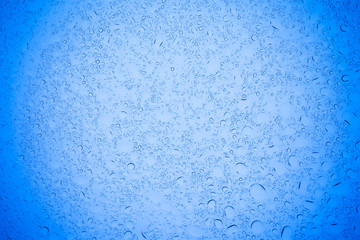 Rain droplets on blue glass background, Water drops on blue glass.