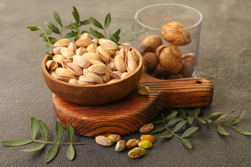 Tasty pistachio nuts on grey background