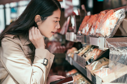 asian chinese businesswoman travel osaka japan on business trip. young office lady working abroad and buying seafood sushi for lunch. woman using cellphone counting exchange rate on calculator