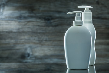 two skincare sprayers on dark background