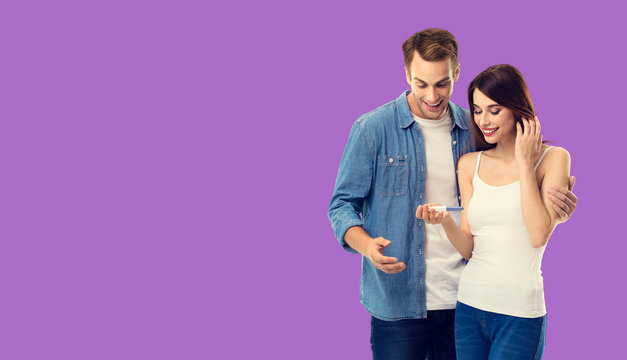Love, new parents and happy family concept - young happy couple, finding out results of a pregnancy test. Purple violet color background. Copy space for some text.