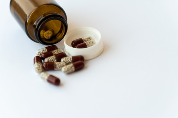 Medicine and pills. Medicines on a white background close-up. Brown glass bucket with capsules...