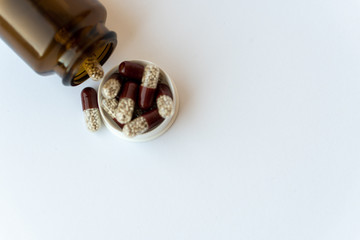 Medicine and pills. Medicines on a white background close-up. Brown glass bucket with capsules...