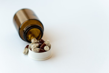 Medicine and pills. Medicines on a white background close-up. Brown glass bucket with capsules...