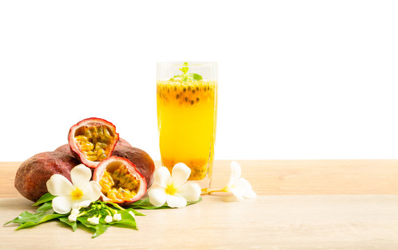 A glass of passionfruit juice with mint and group of purple skin passionfruit plant, sliced and round fruits on wooden table, isolated on white background, die cut with clipping path image