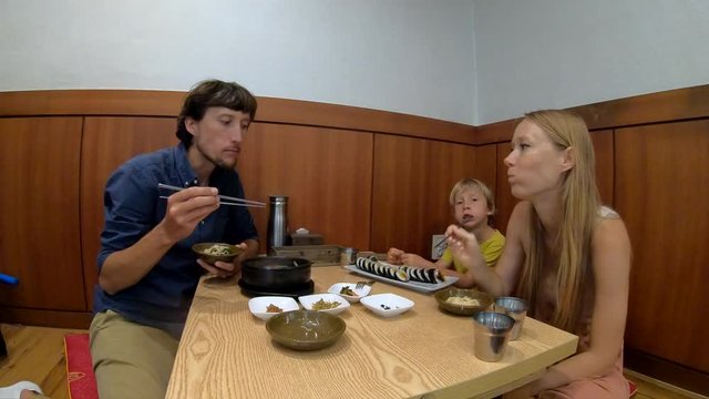 Family enjoy traditional korean food noodle and kimpab in a restaurant