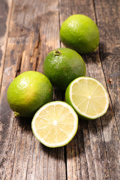 Naklejka green lemon half on wood background