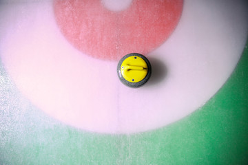 curling stone on ice near the home colorful background