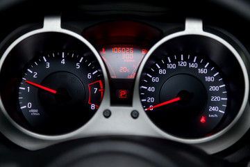 The dashboard of the car is glowing white with red arrows at night with a speedometer, tachometer and other tools to monitor the condition of the vehicle in modern style on black isolated background