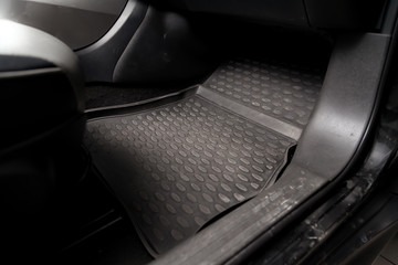 Dirty car floor mats of black rubber under passenger seat in the workshop for the detailing vehicle...