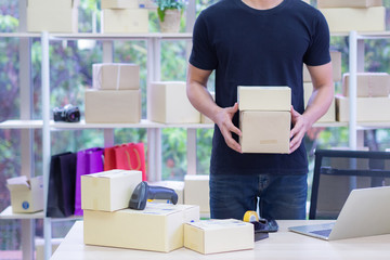 Businessman in black casual holding parcel box while standing in the office