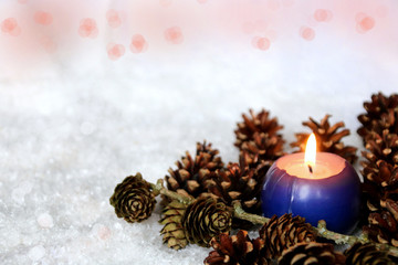 kerze und zapfen im schnee