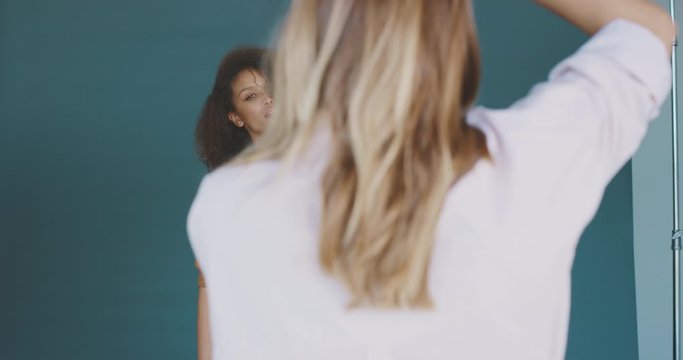 Beautiful african american woman modeling for a fashion photographer, behind the scenes of a professional studio photographer taking photos