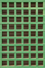 Green color steel grating grid and gray wall background.