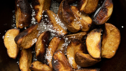 Baked potato wedges with coarse salt. Fast food, rustic food