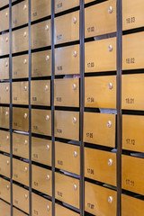 Vertical photo of mailbox array at postal room in condominium