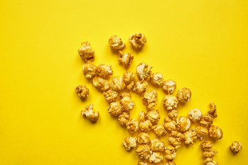 Popcorn with caramel on bright yellow background