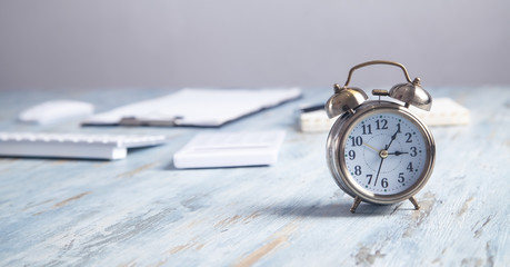 Alarm clock with business objects on the desk.