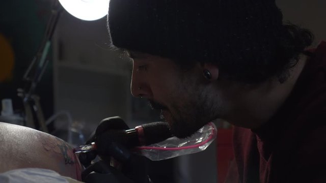 Male Tattoo Artist Tattooing A Client's Shoulder - Close Up