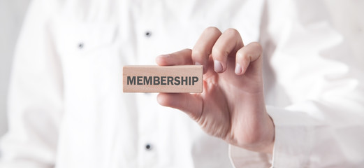 Business girl showing Membership word on wooden block.