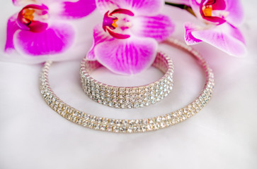 Bracelet and necklace on white fabric and purple Orchid