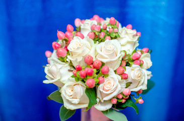 Wedding bouquet of beige roses on a blue background