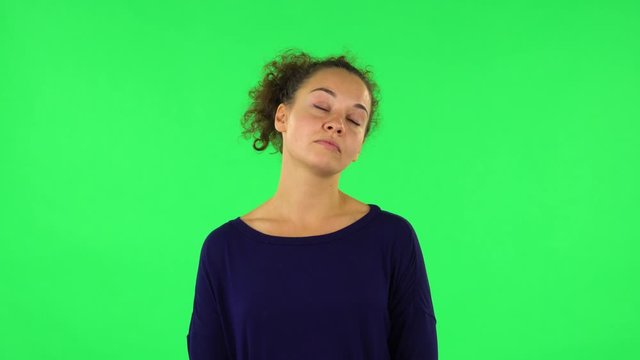 Portrait of curly woman standing waiting with boredom. Green screen