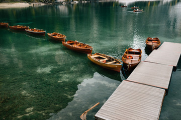 Obraz premium A stunning romantic vacation spot for the whole family with typical wooden boats on an alpine lake, Lago di Braies