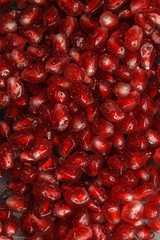 Pomegranate seeds with water drops. Texture for the background. Ripe berries of pomegranate. Red texture of the granules in the macro.