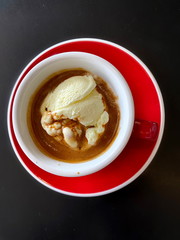 Top view,  red cup of espresso coffee with vanila icecream on black table background.