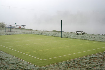 Green sports field in the fog near the Vltava river