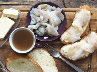 Breakfast, lunch, snack. Sandwiches with butter and freshly salted fish pike on a cutting kitchen board. XE fish salad. Wooden background.