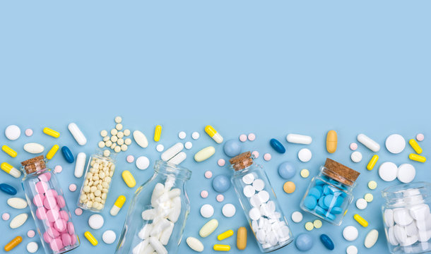 Composition of medicine capsules, tablets, drops and pills on blue