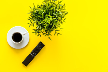 Television air recording concept. TV remote on yellow background top-down copy space