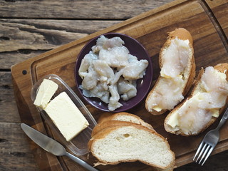 Breakfast, lunch, snack. Sandwiches with butter and freshly salted fish pike on a cutting kitchen board. XE fish salad. Wooden background.