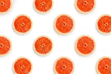 Halves of grapefruit on a white background. Symmetrical background from pieces of red grapefruit staggered.