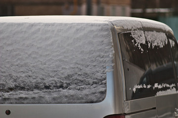 fresh snow on the car in the winter morning