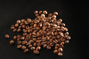 Brown roasted coffee beans on dark background. Espresso dark, aroma, black caffeine drink. Closeup isolated energy mocha, cappuccino ingredient.