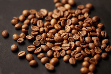 Brown roasted coffee beans on dark background. Espresso dark, aroma, black caffeine drink. Closeup isolated energy mocha, cappuccino ingredient.