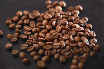 Brown roasted coffee beans on dark background. Espresso dark, aroma, black caffeine drink. Closeup isolated energy mocha, cappuccino ingredient.