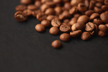 Brown roasted coffee beans on dark background. Espresso dark, aroma, black caffeine drink. Closeup isolated energy mocha, cappuccino ingredient.